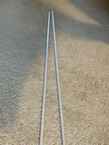 A pair of silver alignment sticks placed on a beige carpeted floor.