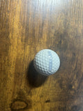 HD golf sim ball strip on a golf ball on a wooden table. 