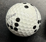 A close-up image of a white golf ball with black dots pattern, which is designed to be read by the Rapsodo MLM2PRO launch monitor.